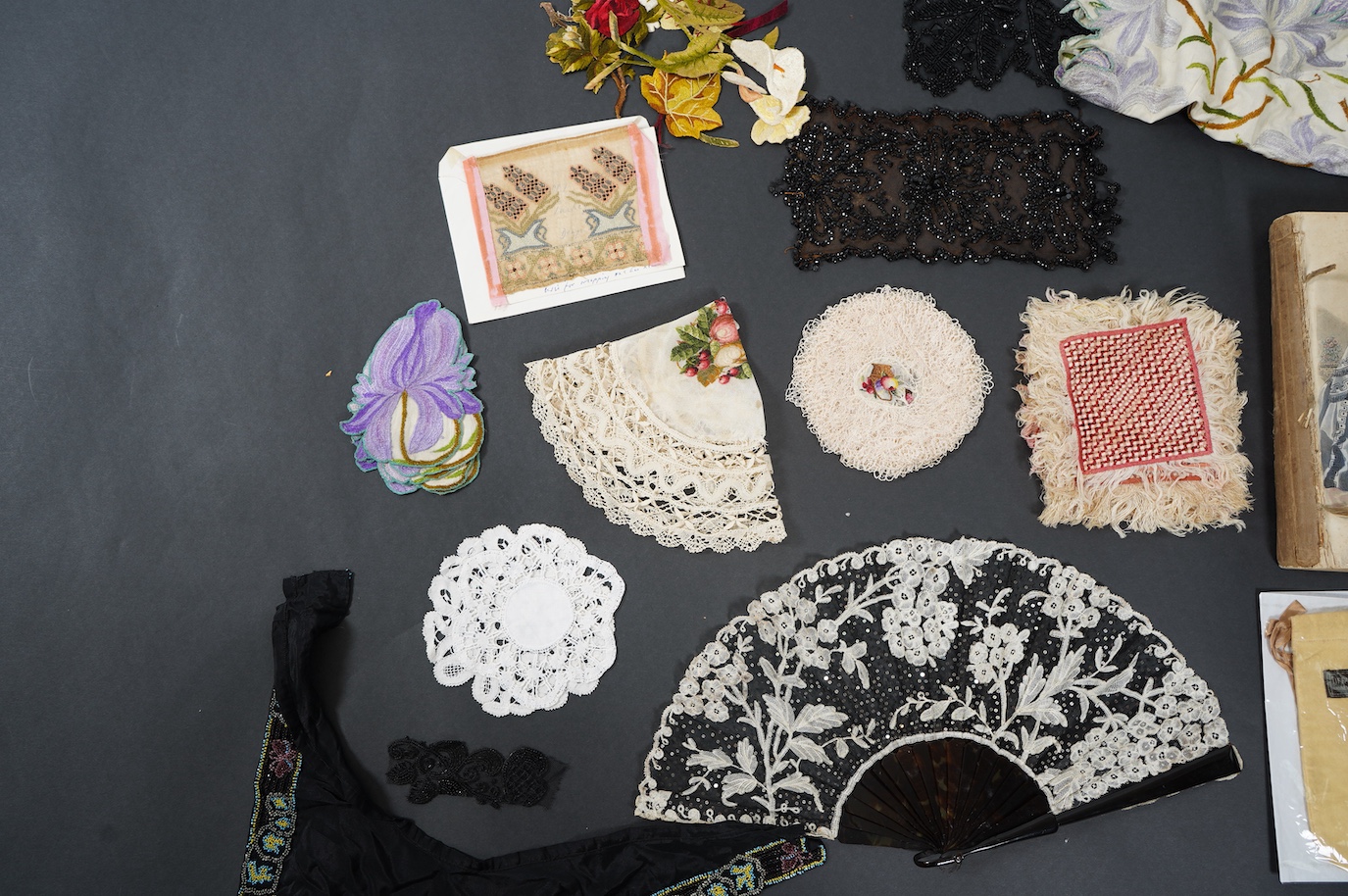 A French tortoiseshell, net, sequin and Honiton bobbin lace fan, with a collection of Jet appliques, a bead work fronter, embroidered mats and silk mats, an early Tiffany &Co poshette and embroidered appliqués and a Le M